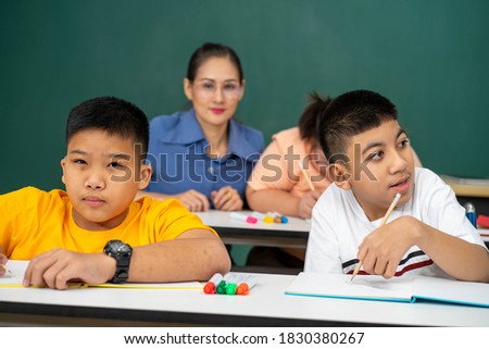 selected focus of disability kid on wheelchair with Autism child in special classroom with blurred background of teacher 