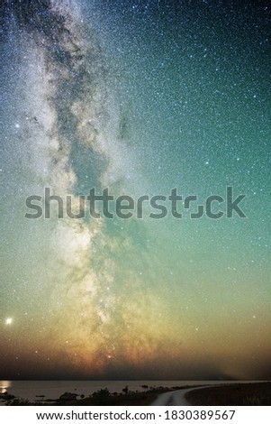 Dirt road in coastal landscape with the Milky Way over the ocean on an summer night, Sweden