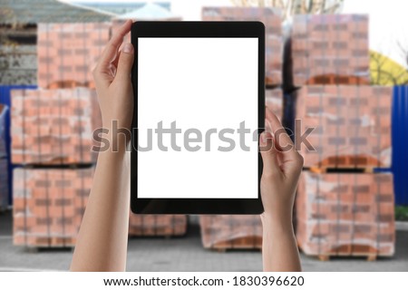 Wholesale trading. Woman using WMS app on tablet at warehouse, closeup  Royalty-Free Stock Photo #1830396620