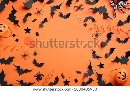 Frame made with Halloween decor elements on orange background, flat lay. Space for text