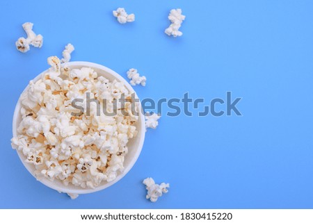Popcorn in bowl on a blue background. Close up. Top view.