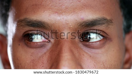 Extreme close-up of african american man eyes looking up , down and sideways Royalty-Free Stock Photo #1830479672