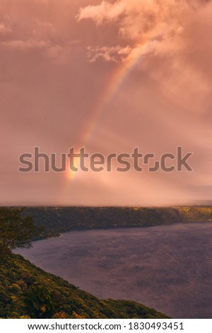 A beautiful view of a dramatic sky and rainbow during sunset on Laguna de Apoyo from Mirador de Catarina, Nicaragua, Central America