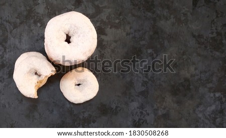 donuts with icing sugar with copy space on dark wooden
