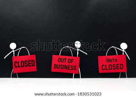 Business closure and bankruptcy concept. Stick man figure holding red Closed signage in black background with copy space.