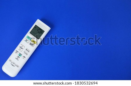 A white
Air conditioner remote control on a blue background