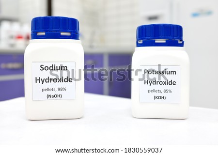 Selective focus of a bottle of pure sodium hydroxide and potassium hydroxide chemical compound. Chemistry research laboratory background with copy space. Royalty-Free Stock Photo #1830559037