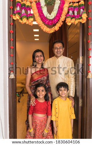 Family in tradional wear standing on the entrance door in an occassion Royalty-Free Stock Photo #1830604106