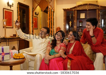 Family in ethnic wear at home taking selfie on diwali Royalty-Free Stock Photo #1830617036