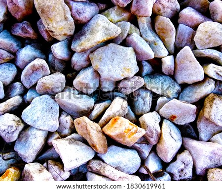 Set of lilac, white and rust-brown stone for landscape design, garden paths, composition sea pebbles close-up. Nature background horizontally with a small size of pebbles tinted in lilac color