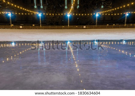 Empty ice rink with bright christmas decoration and lights