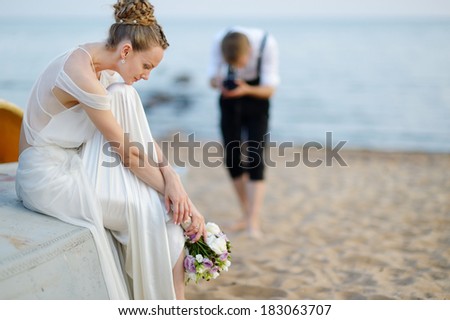 Bride posing for her groom while shooting with an old camera