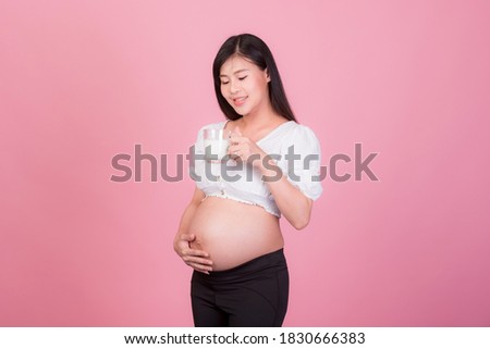 
Beautiful pregnant Asian woman drinking milk on a pink background. , Expectation of a young mother Pregnancy and childbirth pictures