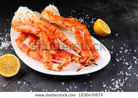 Crab legs in a plate on a dark background. Ready to eat. Royalty-Free Stock Photo #1830670874