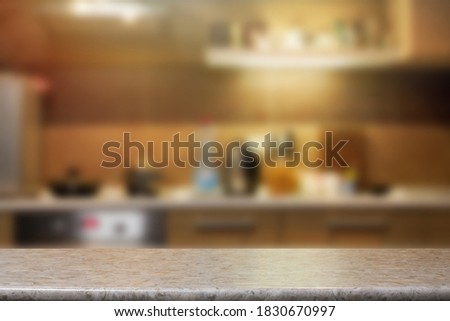 A closeup of a gray countertop against a kitchen background. Template for food photography.