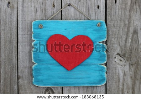 Blank antique blue sign with large red heart hanging on wood background