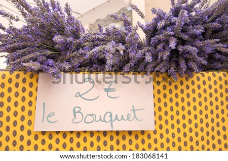 Bouquets of lavender plants on a colorful table an outdoor market, with the price on a handwritten sign