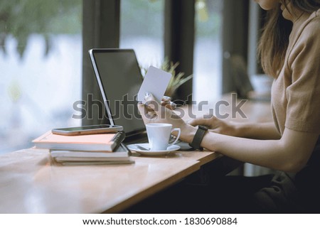 Woman holding credit card and working on laptop or notebook computer. Online shopping concept.