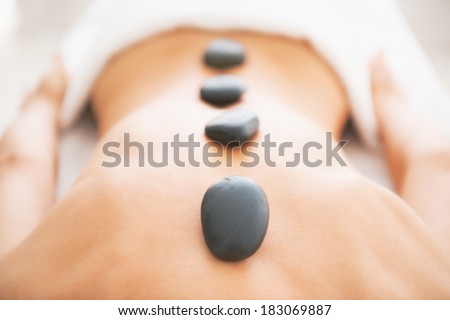Closeup on young woman receiving hot stone massage Royalty-Free Stock Photo #183069887