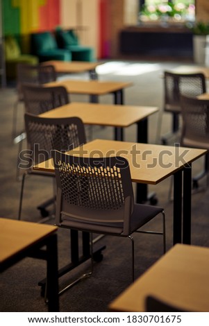 Vertical shot of empty classroom or conference room with desks and chairs, selective focus