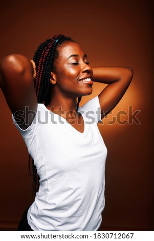 pretty young african american woman posing cheerful gesturing on brown background, lifestyle people concept