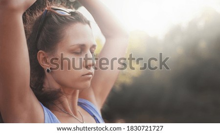 Meditating girl in beautiful style at sunset outdoors. Peaceful, quite and calm atmosphere.