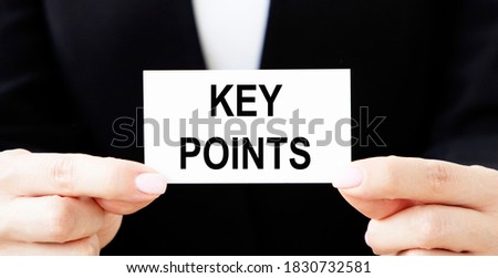 A man holds a business card with the written word KEY POINTS