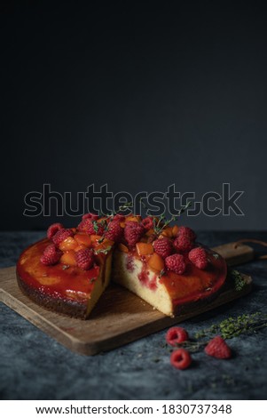 delicious raspberry peach thyme poke cake with dark stone texture background