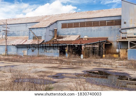 Outside a large abandoned factory on sunny day in the deep south