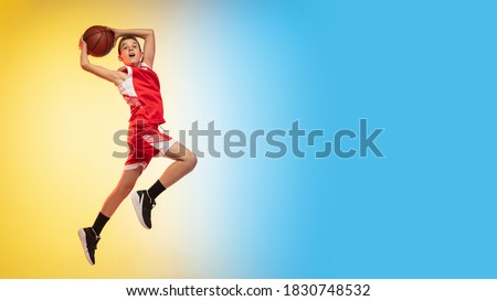 Game. Portrait of young basketball player in uniform on gradient studio background. Teenager confident practicing with ball. Concept of sport, movement, healthy lifestyle, ad, action, motion. Flyer