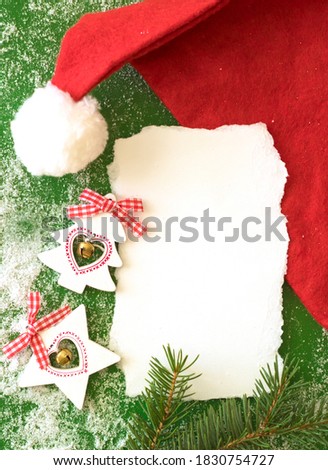 Christmas background with fir branches, snowflakes and red hat
