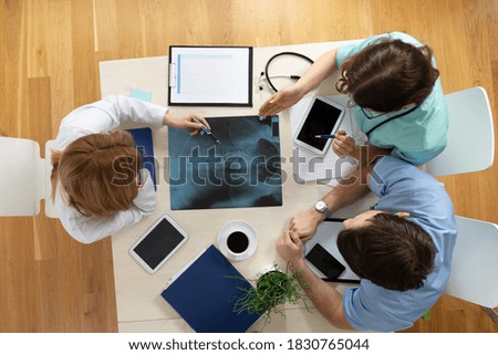 Top view of young professional doctor's meeting over x-ray exam at medical office Royalty-Free Stock Photo #1830765044