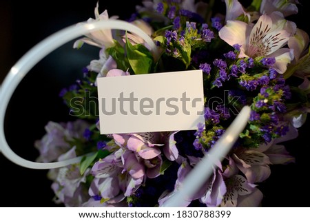 Close-up basket with alstrameria flowers and business card with place for text. a bouquet of flowers for the catalog of the online store. Floral shop concept. Flowers delivery. copy space