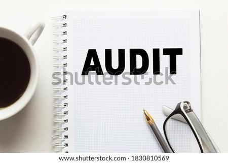 Notepad with inscriptions AUDIT on a white background. business concept.