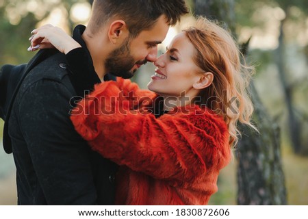 love, relationship, family, season and people concept - smiling couple hugging over autumn natural background