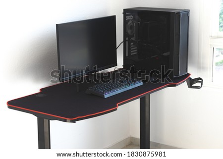 Gaming PC in a gaming desk. Shown in the picture are three gaming monitors standing on the table.