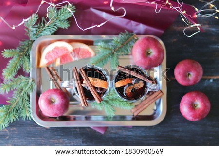 Merry Christmas, cups with mulled wine, spices, fruits, fir branches on a dark wooden table, home comfort concept, seasonal winter holidays
