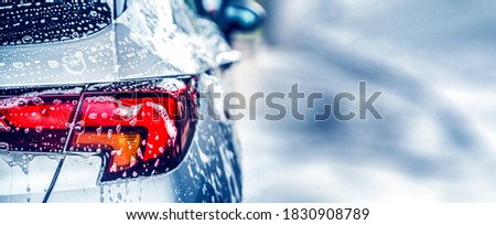 Manual car wash with white soap, foam on the body. Washing Car Using High Pressure Water. Royalty-Free Stock Photo #1830908789