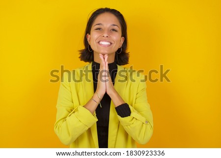 Young businesswoman wearing casual turtleneck sweater and jacket praying with hands together asking for forgiveness smiling confident.