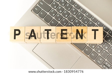 Word patent. Wooden cubes with letters isolated on a laptop keyboard. Business Concept image.