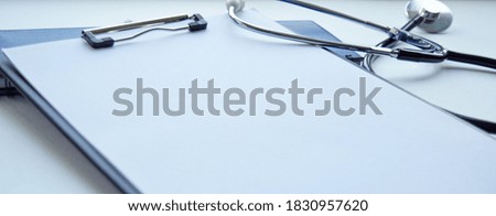 Medical stethoscope and clipboard with a blank sheet of paper. Medical concept. Selective focus.