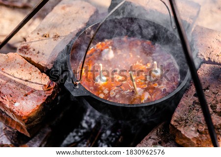 Preparation of raditional armenian pilaf in a cauldron on an open fire.