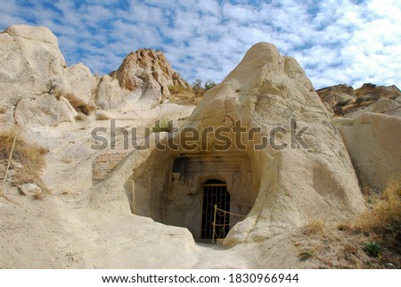 Cappadocia, Turkey. Entrance to a cave carved in stone with ornaments and a grid.