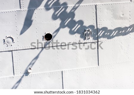 Ship's white hull and shadow of its chains