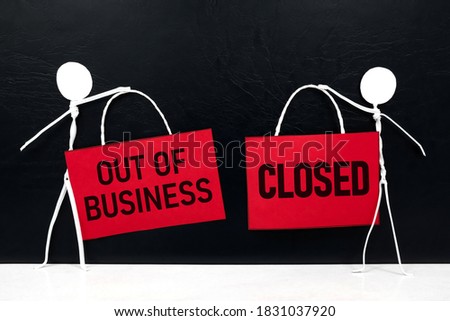 Business closure and bankruptcy concept. Stick man figure holding red we're closed signage in black background with copy space.