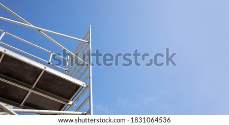 Scaffolding, metal mobile scaffold aginst blue sky background. Under construction, maintenance renovation works concept Royalty-Free Stock Photo #1831064536