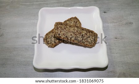 Two slices of nut and seed bread on a pate.