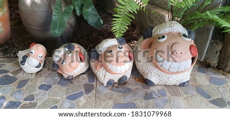 Ceramic figurines, sheep and families in front of the entrance to a restaurant near the garden to welcome customers who come to dine, admire the beauty and take pictures.
