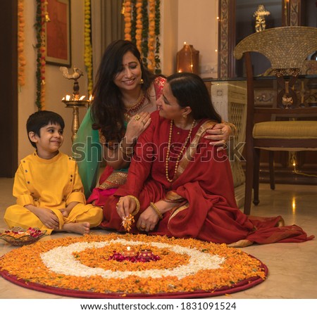 Family at home enjoying festival making rangoli decorations Royalty-Free Stock Photo #1831091524
