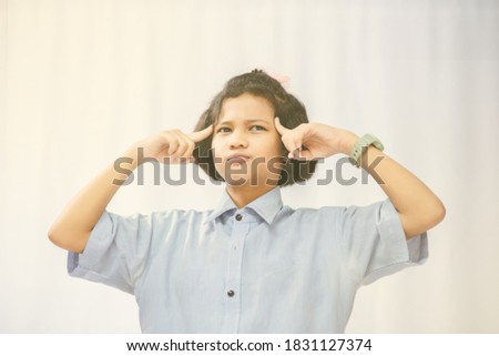 Young girl genius thinks in the room white background.
